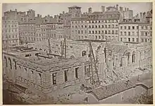 Photographie ancienne en noir et blanc montrant le palais de la Bourse en construction.