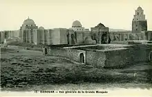 Photographie d'époque (datée de 1900) de la Grande Mosquée de Kairouan, montrant la façade méridionale et orientale, ainsi que le minaret.