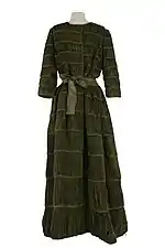 Robe de soirée en lin plissé vert mousse, manches trois quarts et encolure ronde et haute. Créé par Sybil Connolly