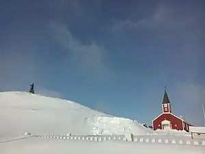 La cathédrale de Nuuk en hiver. La statue de Hans Egede est visible à gauche sur la colline enneigée.