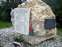 Rocher calcaire massif avec deux plaques commémoratives à la mémoire des combattants du Vercors morts en juillet 1944 et une liste de 12 noms