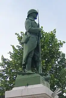 Poilu surmontant le monument aux morts.