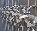 Les grilles du CARAN de fabrication industrielle ont été modifiées par des assemblages de barreaux et de nœuds en fer plat. Œuvre de Pierre Gaucher, ferronnier d’art (maître d'art 1996).