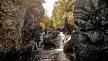 Une chute d'eau dans une gorge rocheuse en automne.