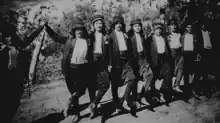 Un groupe d'hommes devant les caméras dansant le dabkeh à Beyrouth en 1955