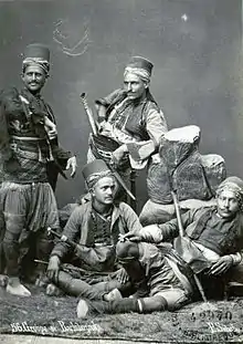 Photographie en noir et blanc d'un groupe de soldats, tenant différentes poses.