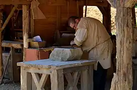 Le tailleur de pierre en biaude, large blouse de travail en grosse toile descendant à mi-cuisse, nouée à la taille par une ceinture.