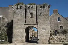 Vue d'une porte massive de granit pénétrant dans des remparts.