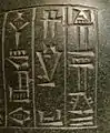 Détail d'une inscription sur une statue en basalte de Gudea : « (1) Gudea (2) ENSÍ (3) (de) Lagash ».