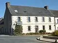 Guerlesquin : bourg, l'ancien hôtel des Voyageurs (avec l'inscription encore visible "Hôtel des Voyageurs tenu par Louis Tilly boucherie").