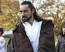 Homme avec une barbe et des cheveux longs.