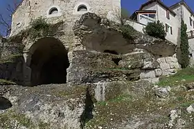 La falaise, avec le chœur à gauche. Le bourg surplombe le site.