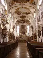 Photographie de la nef d'une église de style rococo, richement ornée de fresques et de stucs.