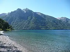 Vue du lac Gutiérrez. Ses rives sont recouvertes d'un beau manteau forestier. Il s'allonge du sud-sud-ouest vers le nord sur quelque 8 kilomètres, dans une vallée d'origine glaciaire entourée par les monts du Cerro Otto, du Cerro Catedral (2 405 mètres d'altitude) et du Cerro de la Ventana.