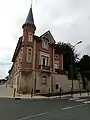 Élégant Hôtel en briques rouges avec sa tourelle derrière l'église St Jean-St Louis.