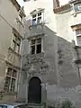 Angle d'une cour de bâtisse Renaissance : fenêtres à meneau et porte d'entrée ornée de pilastres et fronton.