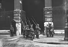 Peloton de onze soldats gardant l'entrée du bâtiment.