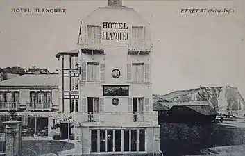 L'hôtel Blanquet à Étretat vers 1890 avec l'enseigne d'Eugène Lepoittevin sur sa façade. Carte postale (début du XXe siècle).