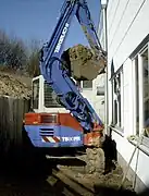 Tranchée creusée au ras d'un mur en déportant la flèche d'une minipelle.