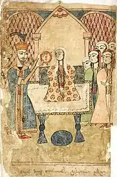 Le roi Rostévan, à gauche, tend la couronne pour la placer sur la tête de Tinatine, assise au centre sur un grand trône, entourée de quelques femmes.