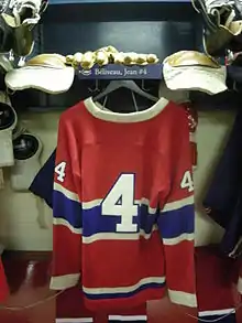 Photographie du maillot rouge des Canadiens accroché dans le vestiaire avec le numéro 4 écrit dessus
