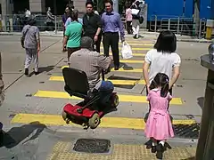 Personne handicapée sur un passage piéton à Hong Kong.