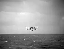 Photographie d'un biplan au-dessus de l'eau