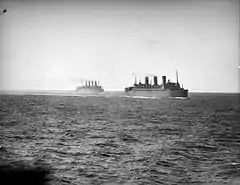 Photographie en noir et blanc représentant deux paquebots au large de l'océan Indien.