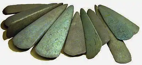 Haches polies découvertes dans le dépôt de Bernon (Arzon, Morbihan).Ces pièces de grande dimension (15 à 28 cm) datent du Ve millénaire av. J.-C. Certaines sont en fibrolite locale, d'autres sont en roches vertes alpines et ont probablement été obtenues par échange.