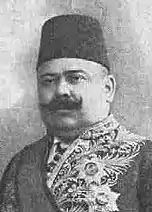 Portrait d'un homme moustachu portant un fez et un costume diplomatique.