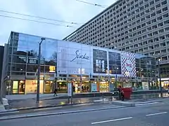 Photographie des Halles de Bocuse (rénovation des Halles) avec en fond l'un des bâtiments d'habitation de l'architecte Zumbrunnen .