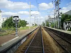 Quais vus de la cabinede conduite d'un trainse dirigeant vers Saint-Lazare.À gauche, un panneau« coupez courant ».