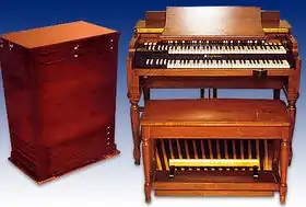 À gauche, une caisse en bois et à droite un petit piano en bois à deux claviers.