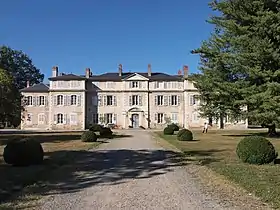 Bâtiment avec nombreuses fenêtres et cheminées sous le soleil.