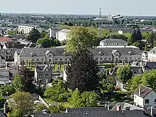 Vue aérienne sur un long bâtiment de style napoléonien, avec fenêtres alignées.