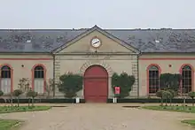 Un grand bâtiment avec une horloge au-dessus de l'entrée