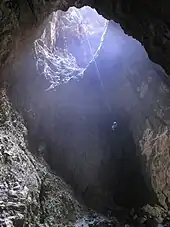 Descente dans un puits d'entrée de Harwood Hole, profond de 183 m, Nouvelle-Zélande.