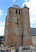 Le donjon, percé de meurtrières,  est flanqué d'une seule tour  en brique à l'angle sud-est comportant un motif en losanges de briques vernissées.