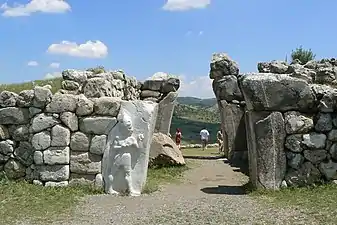 La porte du Roi, avec le bas-relief du dieu-guerrier restauré et les restes de ses arches paraboliques.