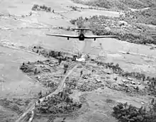 Un Hawker Hurricane Mark Mk.IIC du 42e escadron de la RAF basé à Kangla (Birmanie), plongeant pour attaquer un pont près d'une petite colonie birmane sur la route de Tiddim (mai 1944)