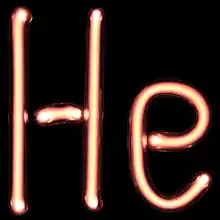 Ensemble de tubes à gaz sous tension formant les lettres « H » et « e », symbole chimique de l'hélium.