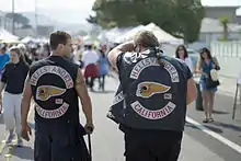 Deux motards Hells Angels, photographiés de dos et portant leur blouson en cuir affublé de leur blason.