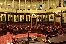  Vue de l'hémicycle du sénat belge depuis la tribune du président. Dans le fond de l'hémicycle, on voit neuf des quinze peintures historiques de Gallait qui décorent le pourtour du sénat belge. Les quinze peintures furent réalisées de 1872 à 1877. Sur la vue, on voit de gauche à droite: Philippe d'Alsace, Jean II duc de Brabant, Guillaume le Bon, Philippe le Noble, Philippe le Bon, Charles Quint, l'archiduchesse Isabelle, l'archiduc Albert, l'impératrice Marie-Thérèse.