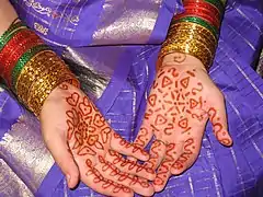 Mains d'une jeune mariée indienne décorées au henné.