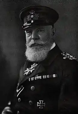 Photo en noir et blanc en buste d'un homme portant moustache et barbe blanche en tenue militaire.