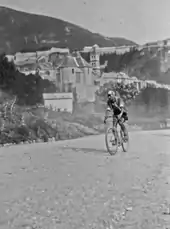 Photographie en noir et blanc d'un cycliste en course.