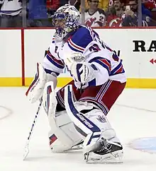 Photographie d'un gardien de but de hockey sur glace en uniforme blanc