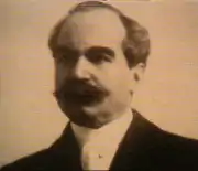 Tête d'homme avec grosse moustache et cravate blanche