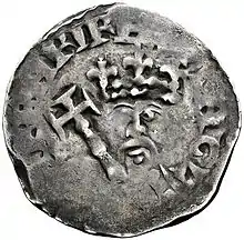Pièce en argent très usée sur laquelle sont difficilement visibles une couronne, un sceptre et un visage barbu