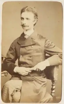 Portrait photographique d'un homme se tenant assis.